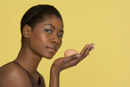 Young woman holding an eggの写真素材