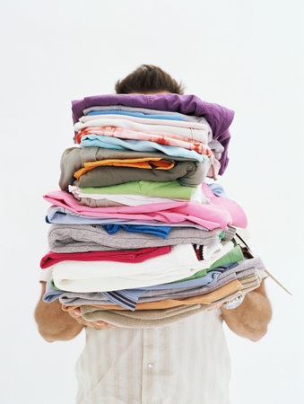 Man with pile of clothesの写真素材