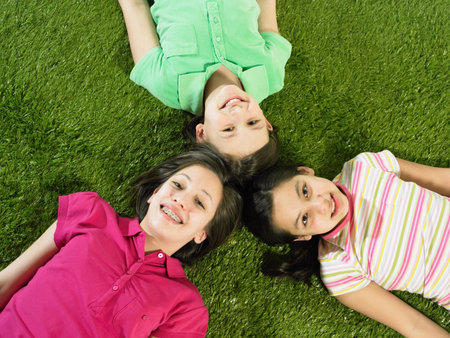 Friends lying on grassの写真素材