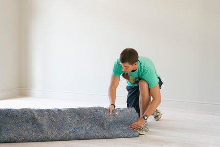 Man Unrolling Under Carpetの写真素材