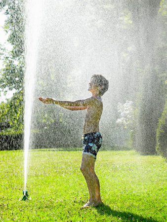 Boy Under A Water-Jetの写真素材