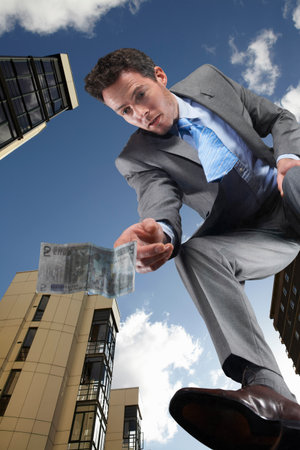 Businessman Picking Up Discarded Moneyの写真素材