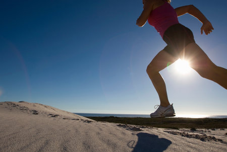 Young Woman Running Over Sand Dunesの写真素材
