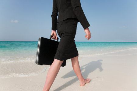 Businesswoman Walking On Tropical Beachの写真素材