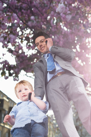 Father And Son Talking On Cell Phonesの写真素材