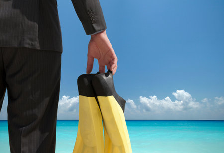 Businessman Carrying Fins On Beachの写真素材