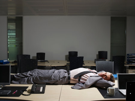 A Man Sleeps At His Deskの写真素材