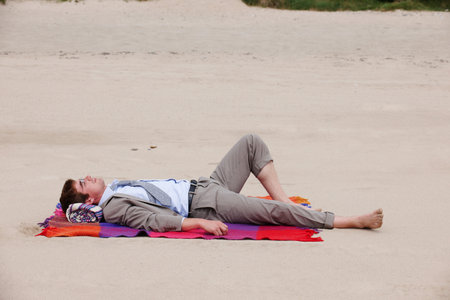 Businessman Laying On Beachの写真素材