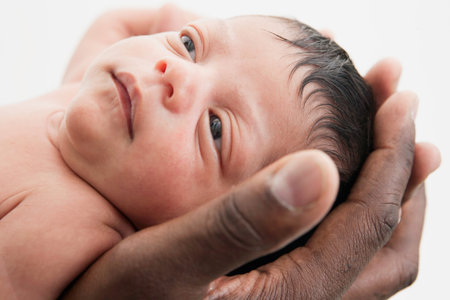 Father Holding Head Of Young Babyの写真素材