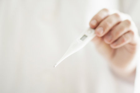 Close Up Of Man Holding Thermometerの写真素材