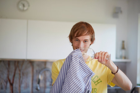 Man Polishing Wine Glass In Kitchenの写真素材