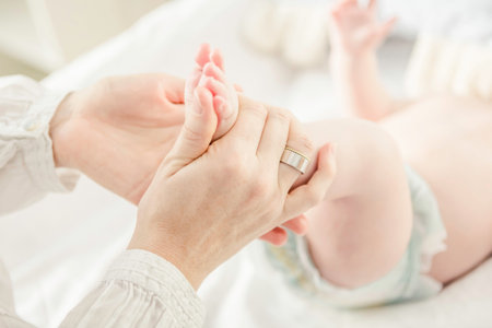 Mother Holding Baby Boy's Feet, Close Upの写真素材