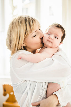 Mid Adult Mother Kissing Baby Boyの写真素材