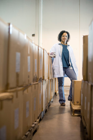 Female Warehouse Worker With Cardboard Boxes