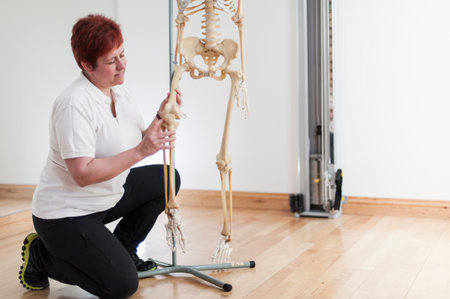 Woman Holding Leg Of Model Skeletonの写真素材