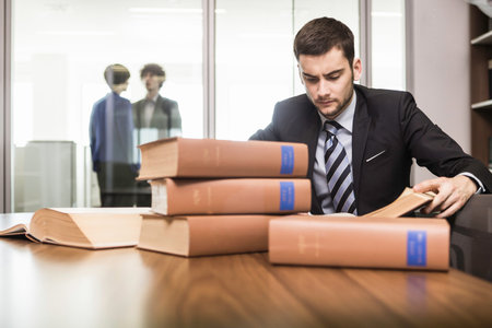 Male Lawyer Working At Desk With Booksの写真素材