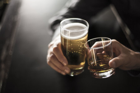 Close Up Of Two Men Toasting Drinks In Barの写真素材