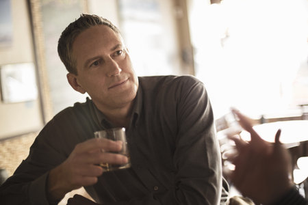 Two Businessmen Chatting In Wine Bar