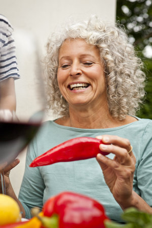 Mature Woman Holding A Red Pepperの写真素材