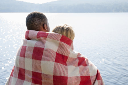 Young Couple Wrapped In Blanket By Lake, Hadley, New York, Usaの写真素材