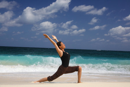 Mature Woman In Warrior Pose On Beach, Paradise Island, Nassau, Bahamasの写真素材