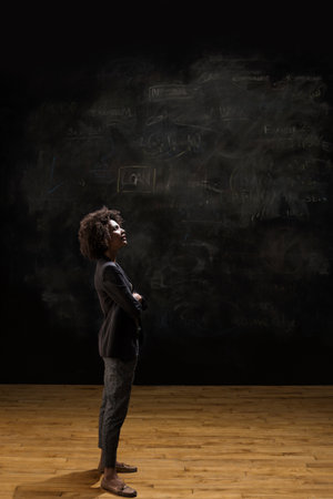 Businesswoman Standing By Blackboardの写真素材