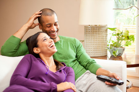 Happy Couple Relaxing And Watching Televisionの写真素材