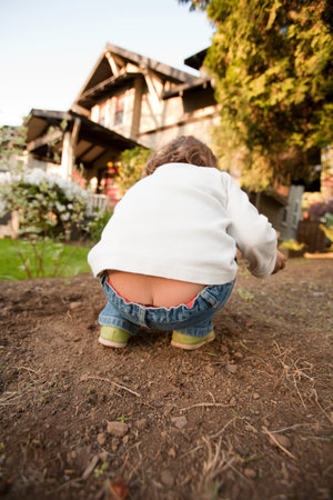 Young Girl Bending In Gardenの写真素材
