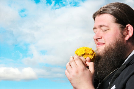 Bearded Man Smelling Flowersの写真素材