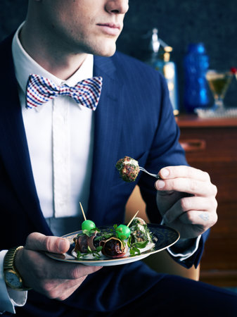 Retro Styled Man Eating Plate Of Appetizers