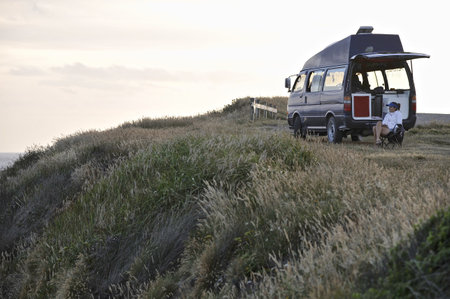 Woman Sitting By Campervan, New Zealand