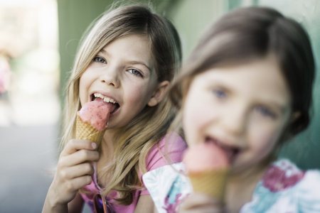 Two Young Girls Eating Icecreamの写真素材
