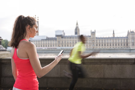Female Trainer Timing Male Runner On Southbank, London, Ukの写真素材