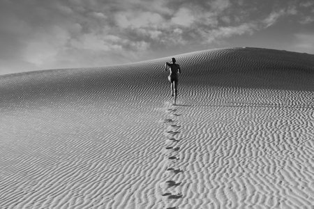 Nude Woman Running In Dessert Leaving Footprintsの写真素材