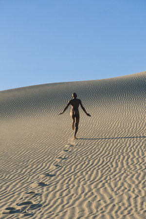 Nude Woman Running In Dessert Leaving Footprintsの写真素材