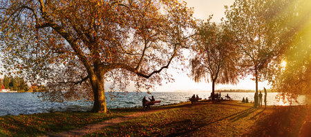 Panoramic View Of Tourists At Sunlit Lake Zug In Autumn, Kanton Of Zug, Switzerlandのeditorial素材