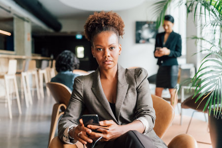 Italy, Portrait of businesswoman with smart phone in creative studioの写真素材