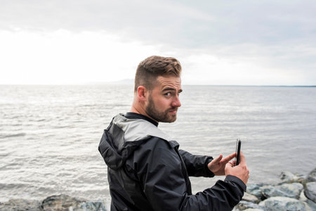 USA, Alaska, Man with smart phone inÃŠKenai Fjords National Park