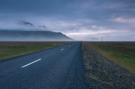 Iceland, Empty Highway 1 crossing landscape at foggy duskの写真素材