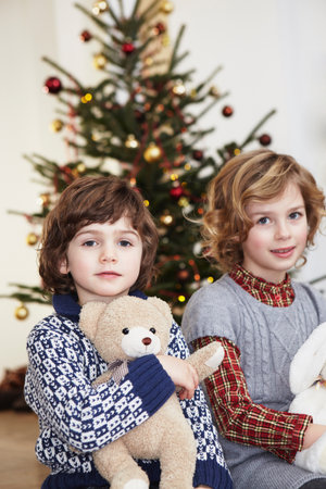 Kids with cuddly toys in front of treeの写真素材