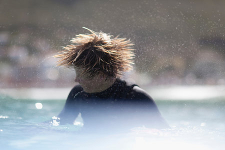 Teenage surfer shaking his hairの写真素材