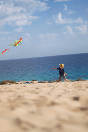 Boy flying kite on beachの写真素材