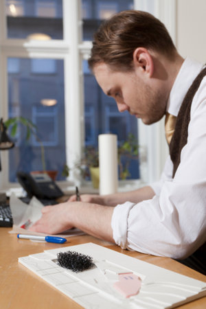 Architect making model at deskの写真素材