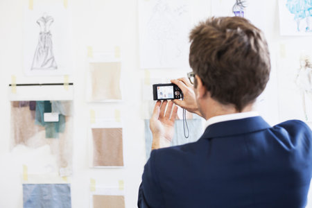 Businessman taking pictures in officeの写真素材