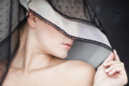 Woman covering her eyes with veilの写真素材