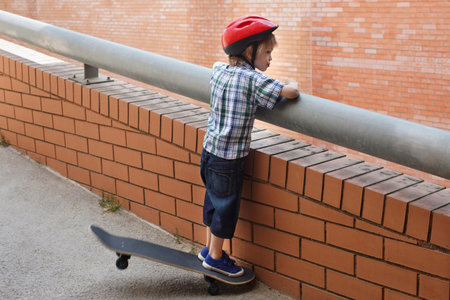 Boy peering over balcony outdoorsの写真素材