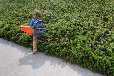 Boy walking by shrubs outdoors