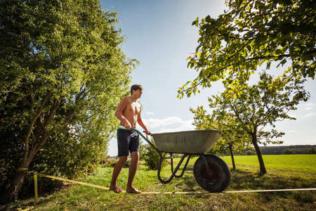 Man pushing wheelbarrow on tight rope