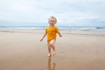 Boy walking in waves on beach