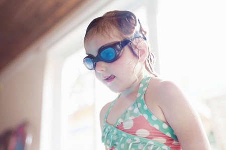 Girl wearing goggles by poolの写真素材